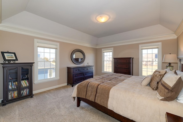 carpeted bedroom with a tray ceiling, multiple windows, and ornamental molding