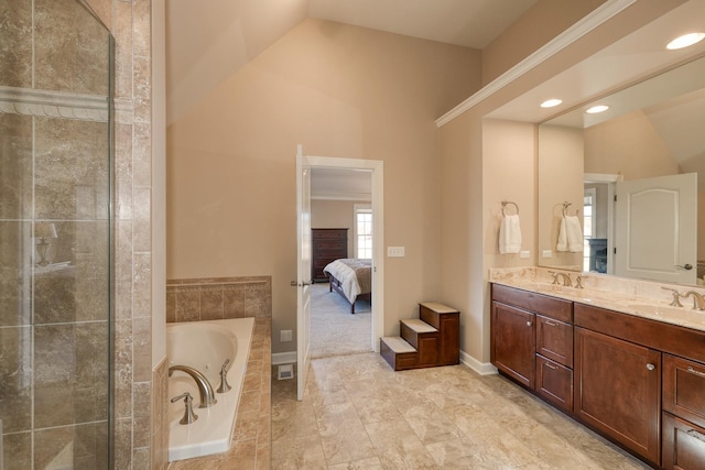 ensuite bathroom with a garden tub, vaulted ceiling, a tile shower, double vanity, and a sink