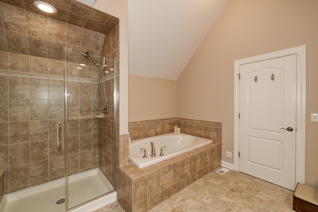 bathroom with a shower stall, a bath, and vaulted ceiling