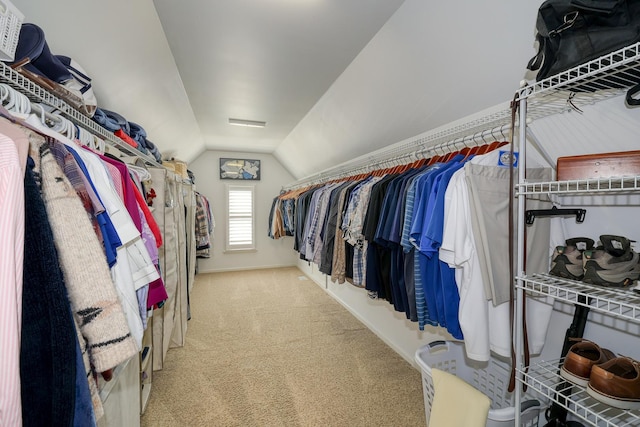 walk in closet with lofted ceiling and carpet