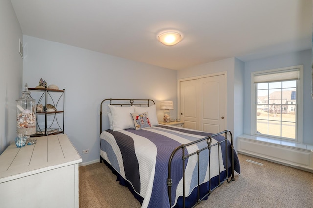 carpeted bedroom featuring a closet and baseboards