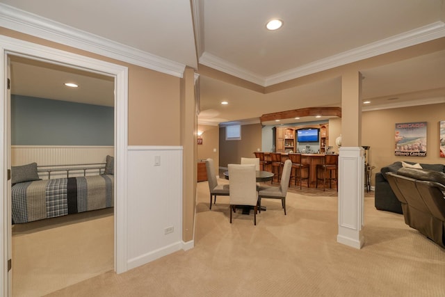 dining area featuring crown molding, recessed lighting, light colored carpet, and a wainscoted wall