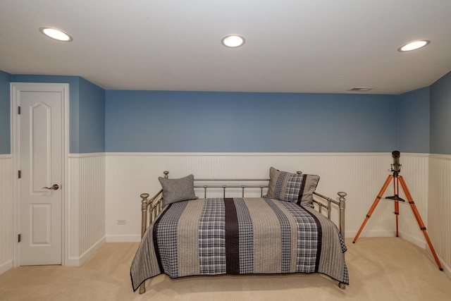 carpeted bedroom with a wainscoted wall, recessed lighting, and visible vents