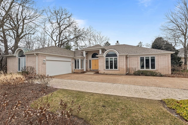 view of front of home featuring a garage, brick siding, a chimney, and roof with shingles