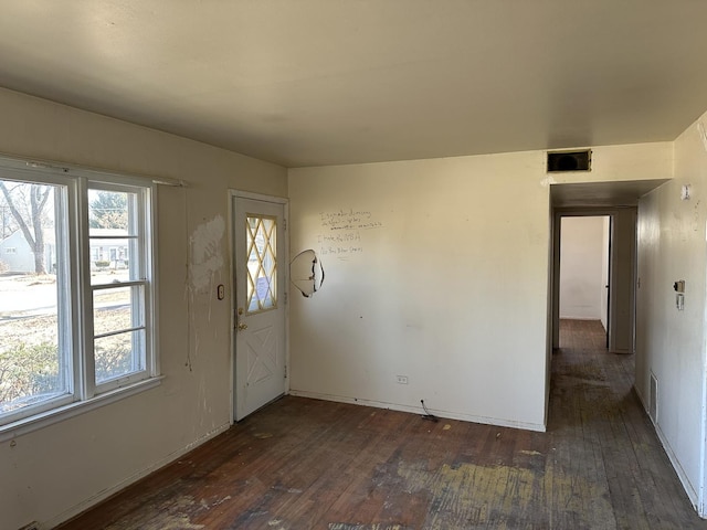 foyer entrance with dark wood-style flooring, visible vents, and a healthy amount of sunlight