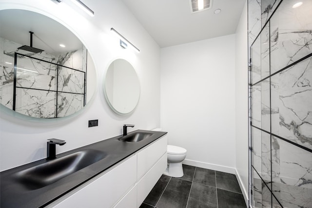 full bath with visible vents, toilet, a sink, a marble finish shower, and baseboards