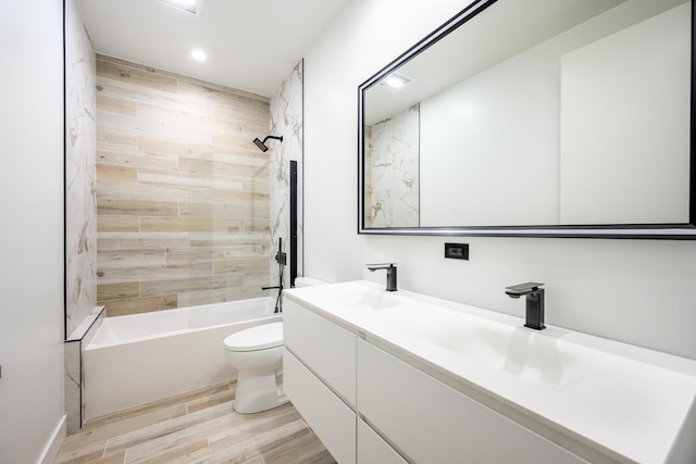 bathroom with toilet, wood finished floors, recessed lighting, washtub / shower combination, and double vanity