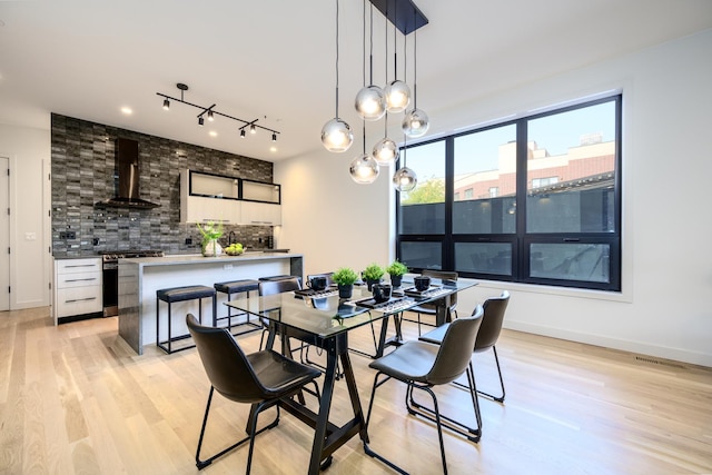 dining room featuring light wood finished floors and baseboards