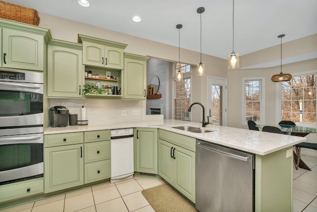 kitchen with stainless steel appliances, a peninsula, a sink, and green cabinetry