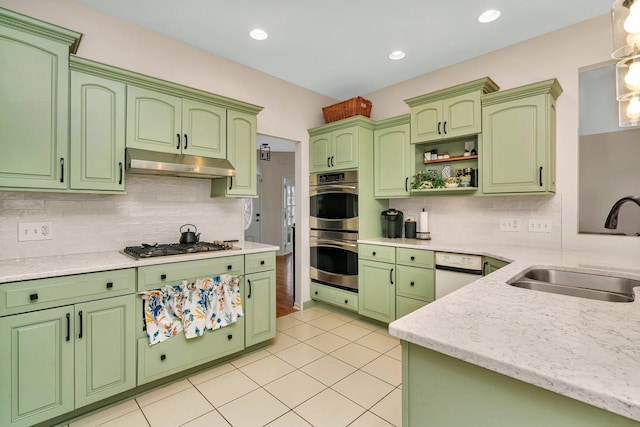 kitchen with appliances with stainless steel finishes, light tile patterned flooring, a sink, and under cabinet range hood