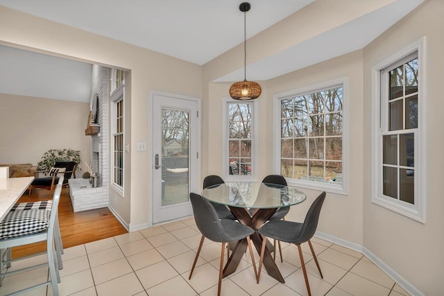 dining area with light tile patterned floors, baseboards, and a healthy amount of sunlight