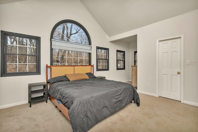 carpeted bedroom featuring lofted ceiling and baseboards