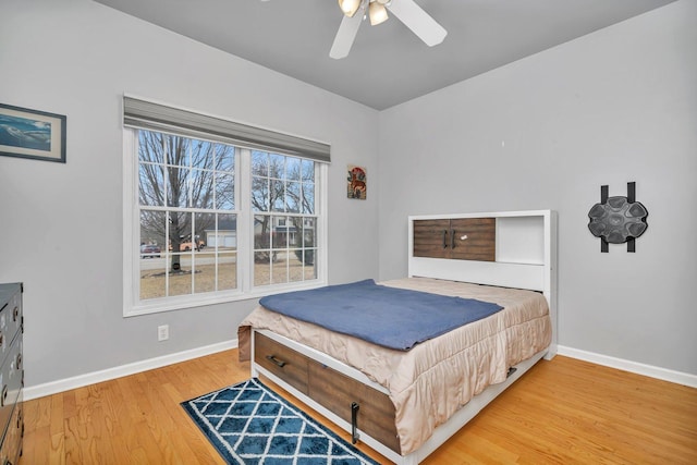 bedroom with ceiling fan, baseboards, and wood finished floors