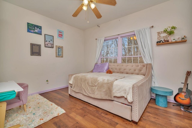 bedroom with a ceiling fan, baseboards, and wood finished floors