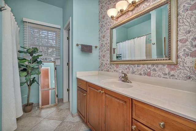 full bath with tile patterned floors, vanity, and wallpapered walls