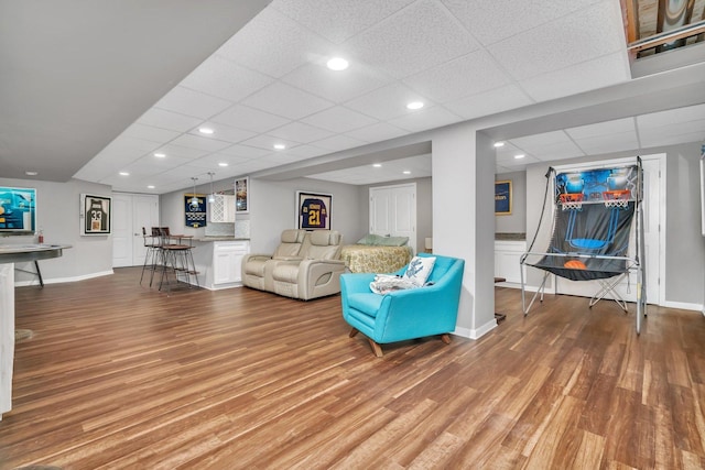 unfurnished living room with light wood-type flooring, baseboards, and a bar