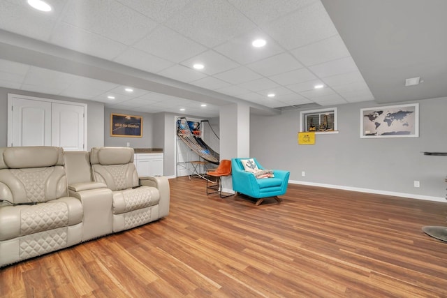 living room featuring recessed lighting, a drop ceiling, baseboards, and wood finished floors