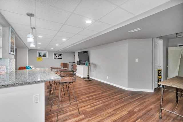 kitchen with light stone counters, recessed lighting, baseboards, and wood finished floors