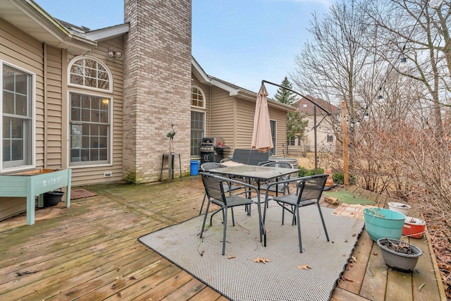 wooden terrace featuring outdoor dining area and area for grilling