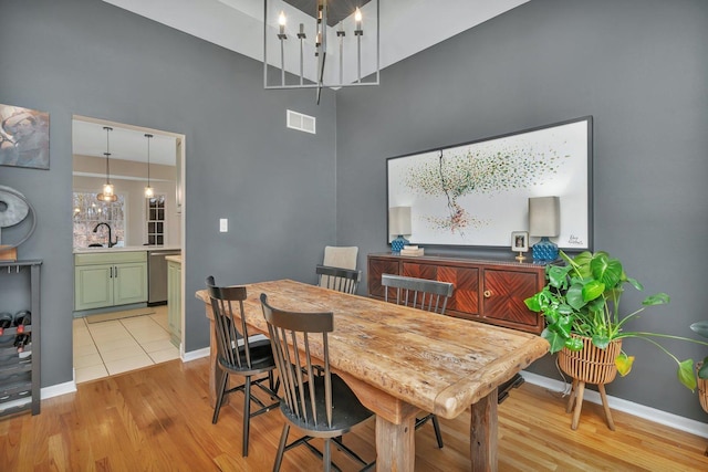 dining area featuring visible vents, light wood-style flooring, and baseboards