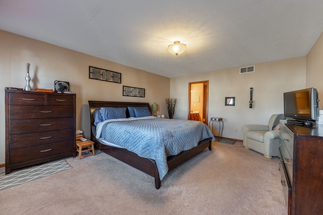 bedroom featuring light carpet, baseboards, visible vents, and ensuite bathroom