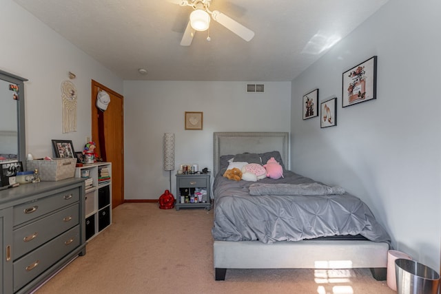 bedroom with visible vents, a ceiling fan, and light colored carpet