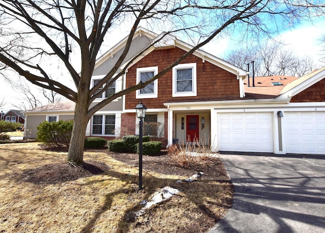 view of front facade with aphalt driveway, an attached garage, and brick siding