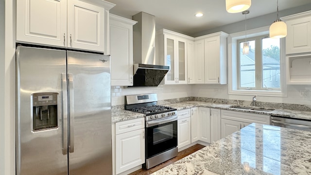 kitchen featuring wall chimney exhaust hood, decorative backsplash, stainless steel appliances, and a sink