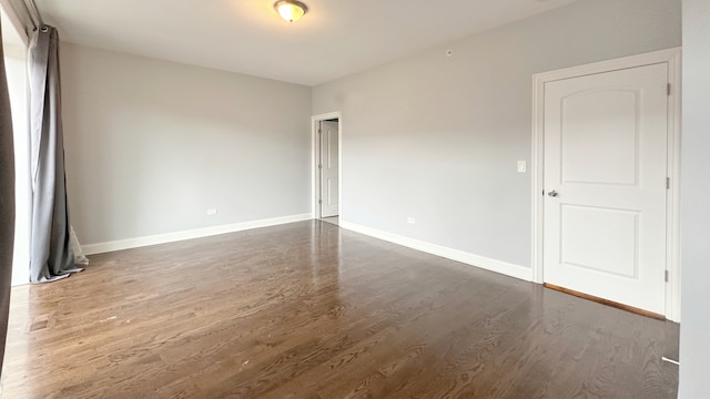 unfurnished room with baseboards and wood finished floors