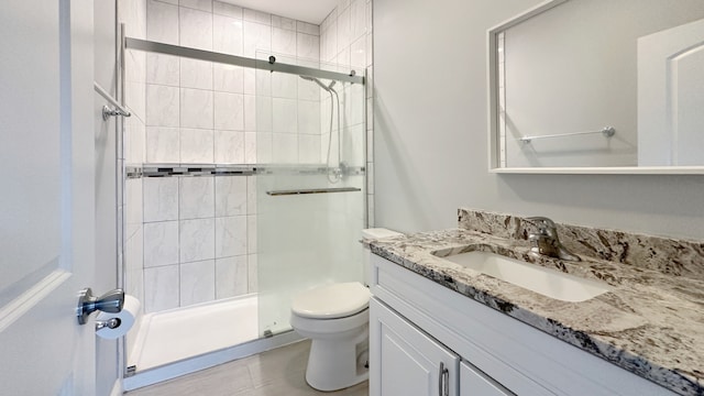 bathroom with vanity, a shower stall, and toilet