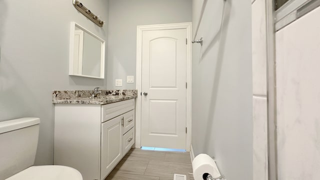 half bathroom with toilet, visible vents, and vanity