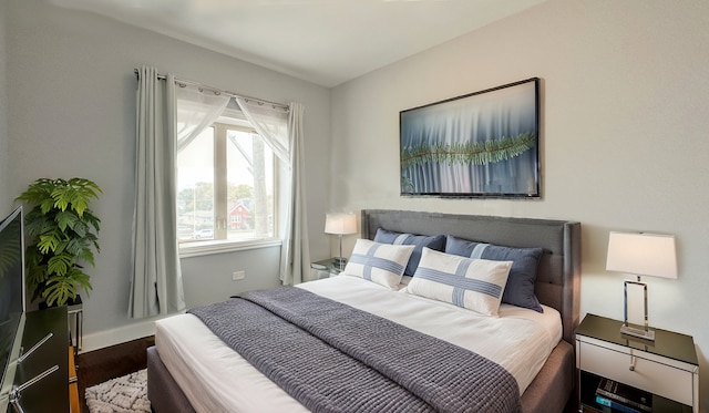 bedroom featuring baseboards and wood finished floors