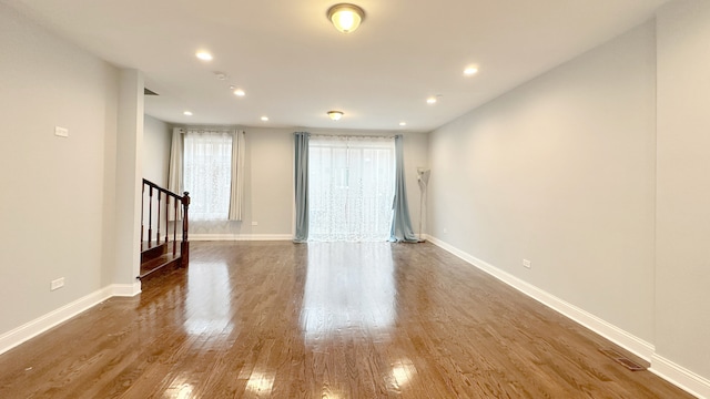 unfurnished room featuring recessed lighting, wood finished floors, visible vents, and baseboards