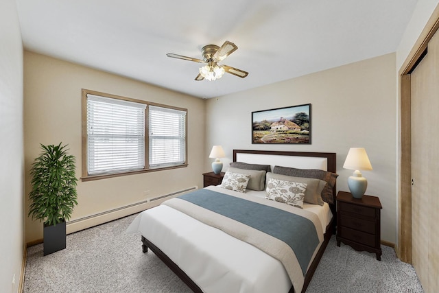 carpeted bedroom featuring a baseboard radiator, ceiling fan, and a closet