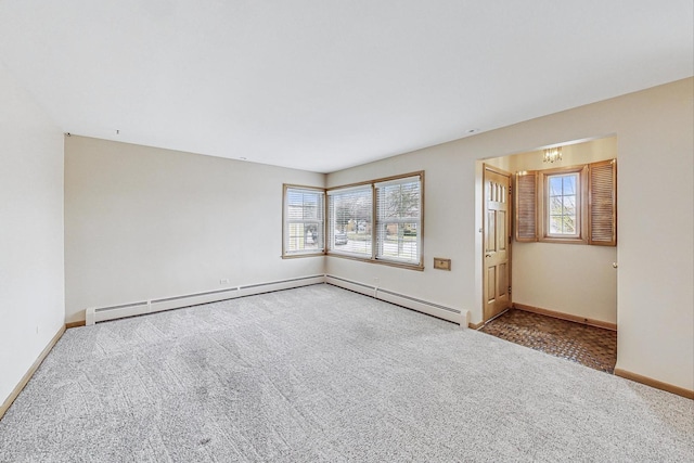 carpeted spare room with a wealth of natural light, baseboards, and a baseboard radiator