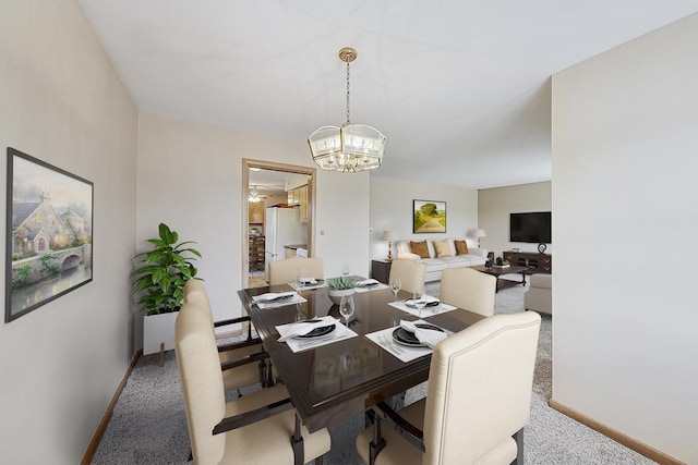 carpeted dining room with baseboards and a notable chandelier