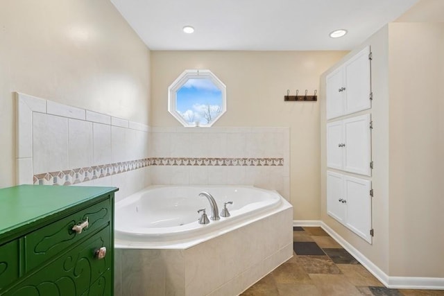 full bathroom with a bath and baseboards