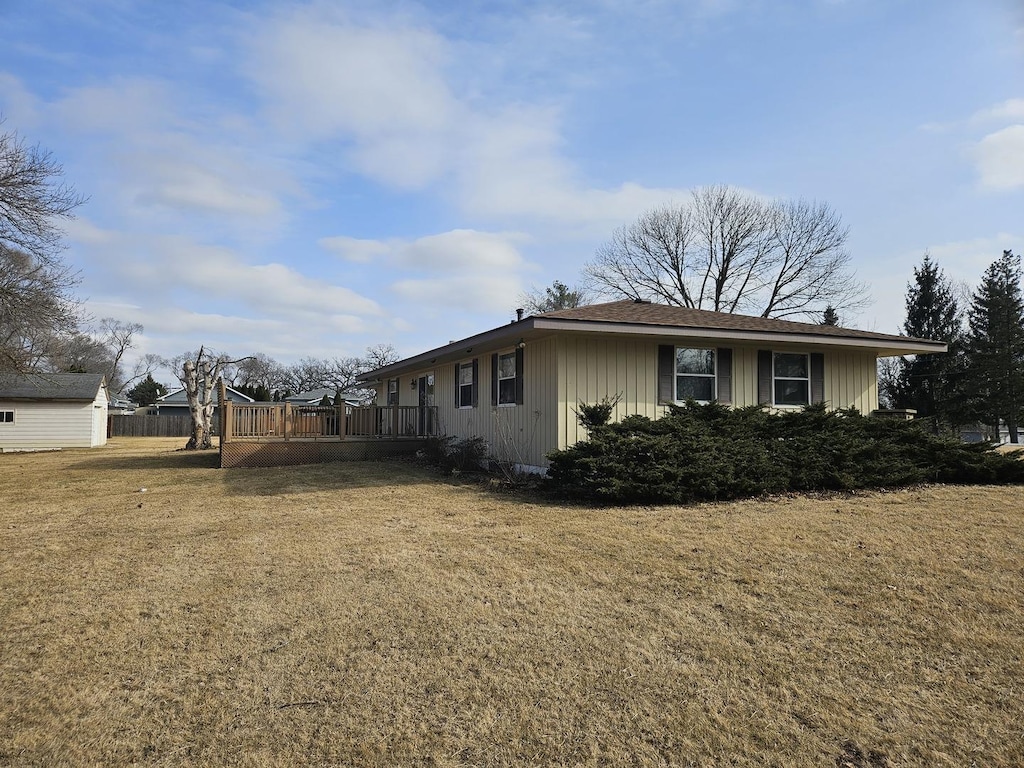 view of side of property featuring a yard and a deck