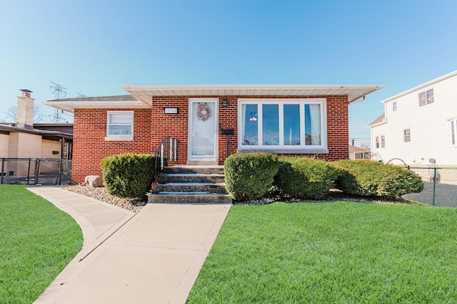 view of front facade featuring a front yard, brick siding, and fence