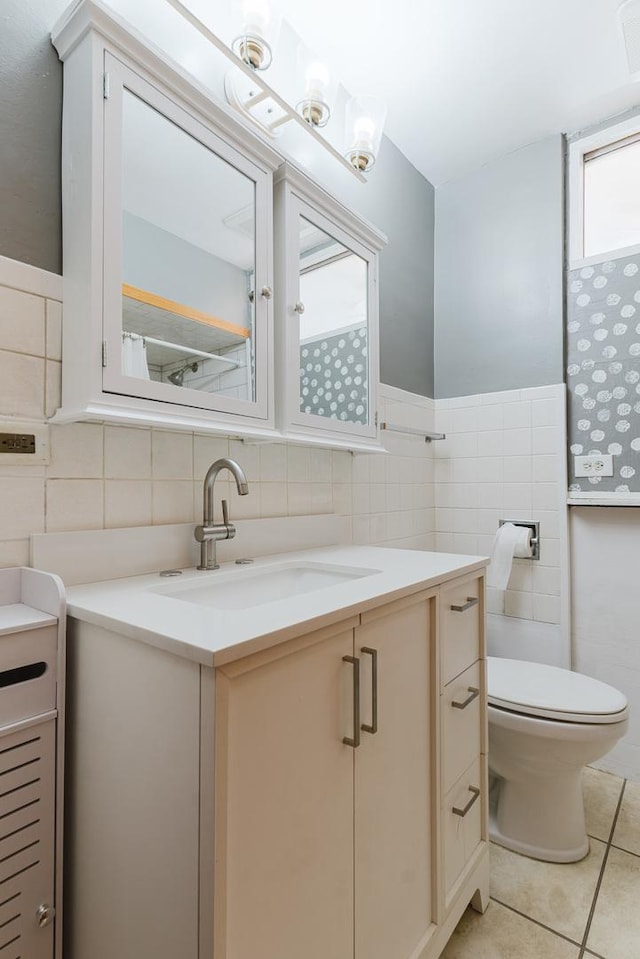 bathroom featuring tile walls, toilet, wainscoting, vanity, and tile patterned flooring