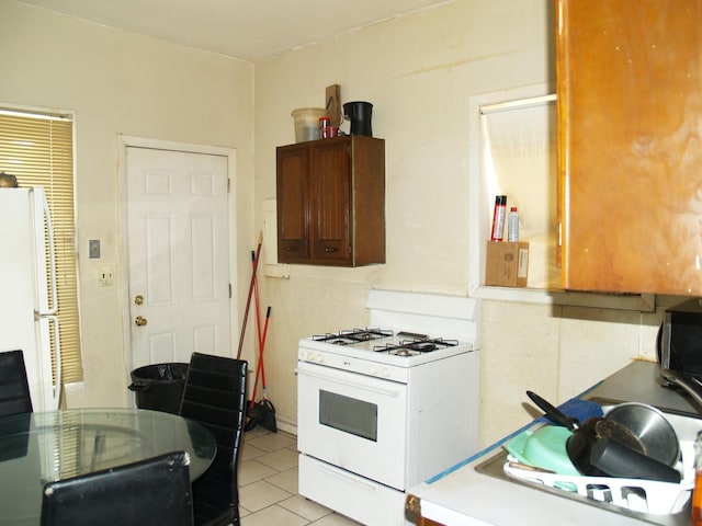 kitchen featuring white appliances, light countertops, and light tile patterned floors