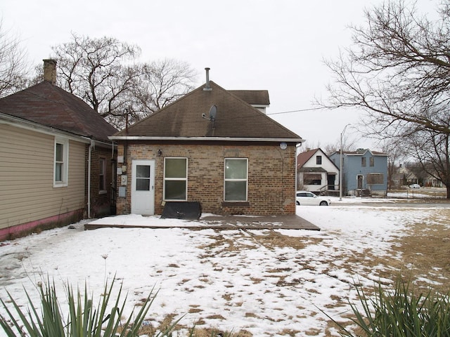 snow covered house with brick siding