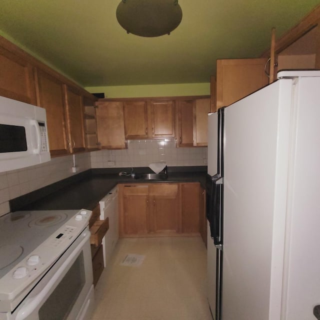 kitchen featuring dark countertops, white appliances, brown cabinets, and backsplash