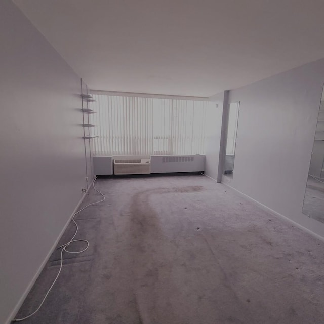 empty room featuring radiator, carpet, and baseboards