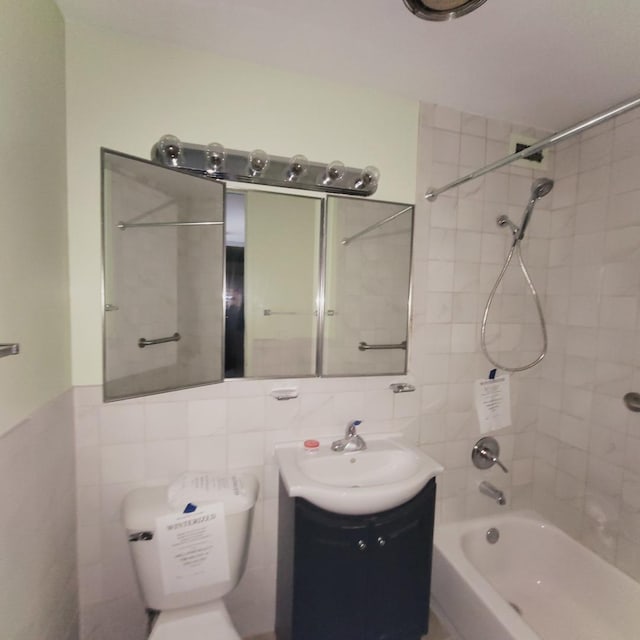 bathroom featuring tile walls, toilet, bathing tub / shower combination, and vanity