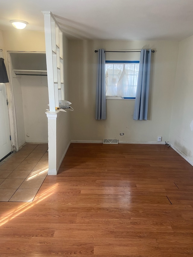 interior space featuring light wood-style flooring, a closet, visible vents, and baseboards