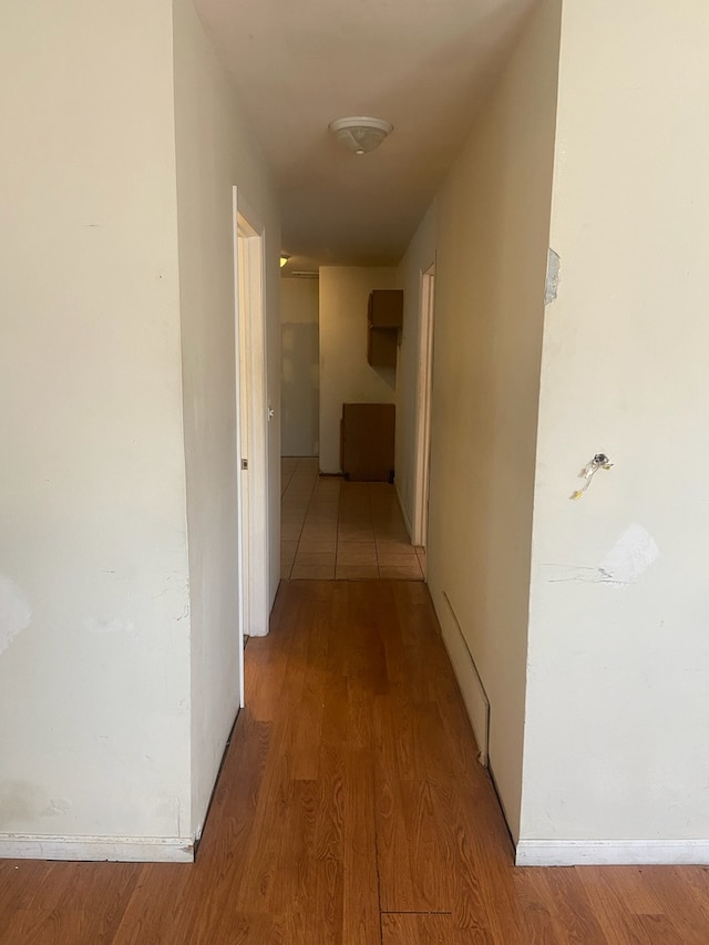 hallway with baseboards and light wood finished floors