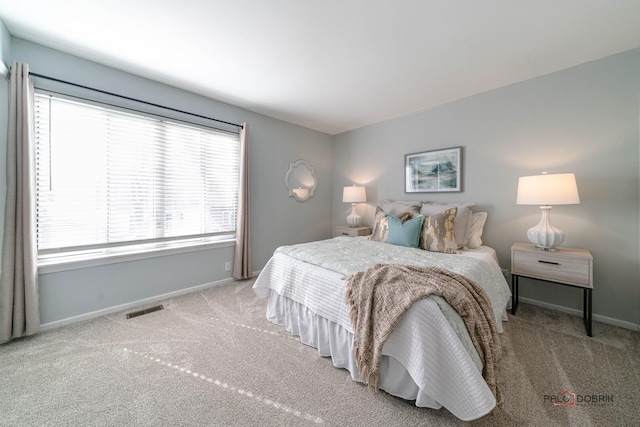 bedroom with carpet floors, baseboards, and visible vents