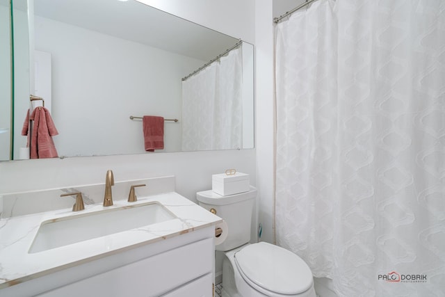 bathroom featuring a shower with shower curtain, vanity, and toilet