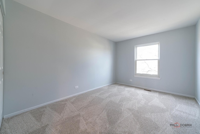 unfurnished room with light carpet, visible vents, and baseboards